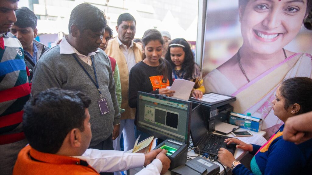 Nuova Delhi, India - 30 dicembre 2016: Un volontario del centro di iscrizione Aadhaar acquisisce informazioni biometriche sulle impronte digitali di un uomo durante la registrazione per la carta Aadhaar o la carta identificativa univoca.