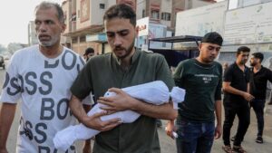 Palestinesi con il corpo di un bambino ucciso in un attacco aereo israeliano, presso l’ospedale Al-Najjar, nella città nel sud della Striscia di Gaza, il 24 ottobre 2023.